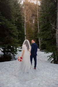 Wedding couples walking in snow in mountains- salt lake city wedding photographer