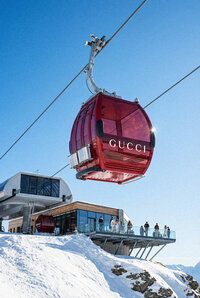 Powder - Gucci branded cable car ascending snowy Alpine mountain - TVS