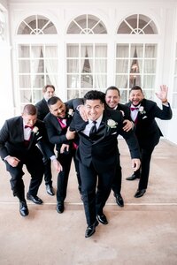 Groomsmen in black tuxedos celebrating at a luxury Orlando wedding