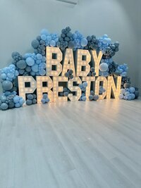 light blue balloons surrounding LEd marquee sign for baby shower