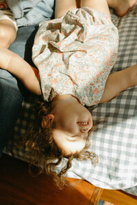 A toddler lays in the sunshine during an at home photo session in Houston TX