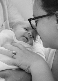 A mother and baby boy close up photo during a newborn photography session in Wilmington, North Carolina