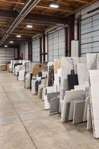 White and gray marble slab remnants displaying distinctive natural veining in a storage rack