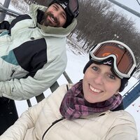 Emily, the photographer of Studio Roscher, smiling with her husband while snowboarding