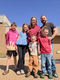 Emily, the photographer of Studio Roscher, smiling with her husband and kids