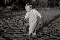 petit garçon qui joue les pieds dans le sable à la plage