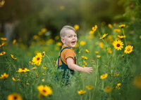 boy-child-smiling-in-yellow-flower-field-box-hill