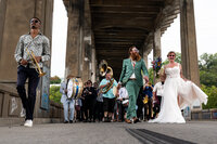 couple-guests-walking-brass-band-12th-street-bridge-wedding