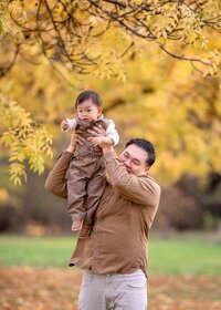 father-lifting-baby-autumn-family-session-melbourne