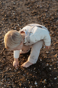 enfant qui cherche des coquillages à la plage