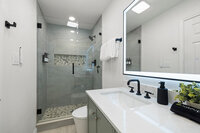 Hallway bath in lakeside retreat, walk in shower, illuminated vanity mirror and luxury toilet