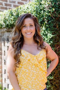 A classic professional portrait taken by Studio Roscher of a female professional smiling in a park
