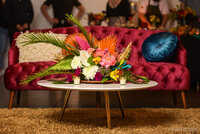Colorful social event lounge with velvet seating, tropical floral arrangement and modern event decor in Phoenix Arizona