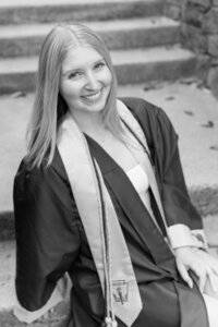 A classic photo taken by Studio Roscher of a happy high school female graduate in her cap and gown in Alexandria, VA