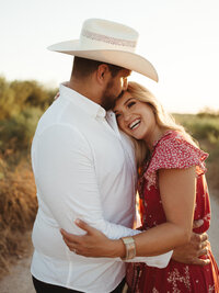 Couple embracing during a golden hour country engagement session photographed by Angie Rich Photography in San Antonio.