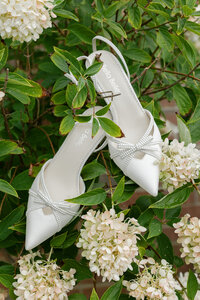 white wedding shoes sitting a top hydrangeas