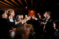 groomsmen-raising-whiskey-glasses-union-kansas-city-wedding