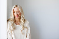 Celeste posed near greenery in a white outfit during a La Quinta branding session