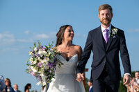 couple-happy-walking-down-aisle-white-iron-ridge
