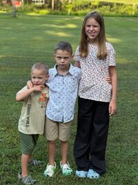 Three of Emily's kids making cute funny faces in a park