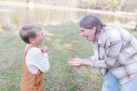 A glossy photograph taken by Studio Roscher of a happy mother and son outside in a park in Richmond, VA