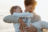 papa et son fils qui jouent à la plage