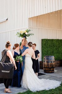 Wedding planner with Weddings & Events by Raina assists with wedding photos