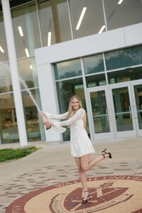 graduate popping a champagne bottle to celebrate during senior years