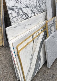 Quartz, marble, granite, and engineered-stone remnants organized inside a spacious warehouse.