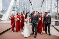 Bride and groom portrait with bridal party walking down the bridge at Nashville Tennessee wedding — Weddings & Events by Raina