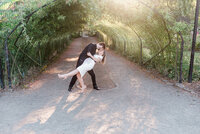 Couple dipping and kissing in front of the rose garden.