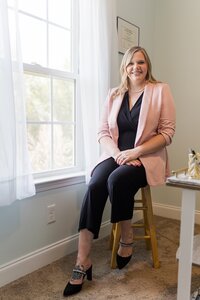 A classic professional portrait taken by Studio Roscher of a female professional smiling in her home office