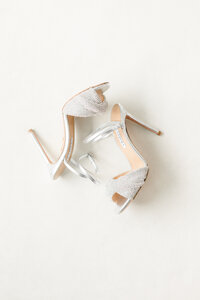 Sparkling silver bridal heels styled as an elegant wedding-day detail.
