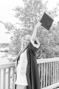 A classic photo taken by Studio Roscher of a happy high school female graduate in her cap and gown in Alexandria, VA