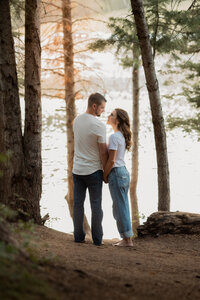 Couples look at each other in front of a lake- utah county photographer