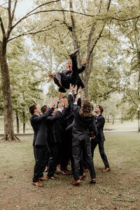 Groomsmen throwing groom in the air portrait at Nashville Tennessee venue — Weddings & Events by Raina