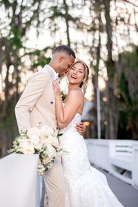 Bride and groom laughing together among greenery at an Orlando wedding