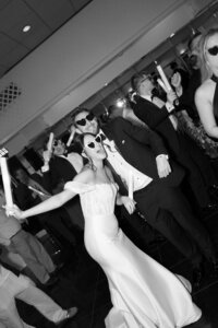 black and white image of bride and groom having fun at their wedding reception