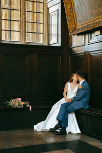 Bride and groom sharing a quiet embrace indoors at their wedding venue
