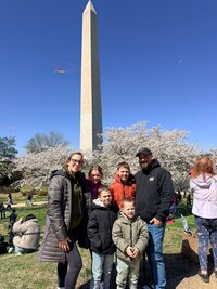 Emily, the photographer of Studio Roscher, smiling with her husband and kids at the Cherry Blossom Festival in Washington, DC