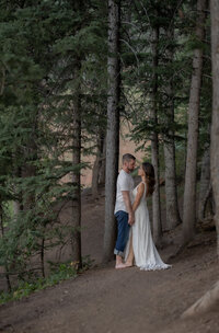 Couple poses in the woods in wedding attire- utah county wedding photographer