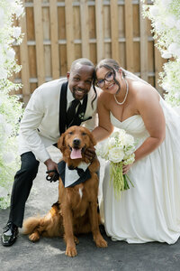 bride and groom posing together with their dog after their ceremony