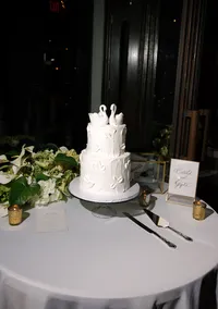 Luxury wedding reception details featuring a textured three-tier wedding cake, romantic floral arrangements, candlelight, and modern reception décor photographed with a documentary storytelling approach.