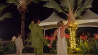Green suit groom with his bride partying to the local band