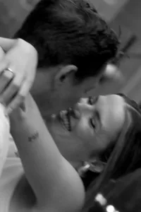 Close up black and white image of couple smiling and kissing