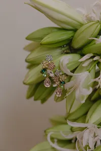 Beautiful gold, silver and green jewelry placed on top of white and green flowers