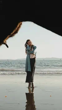 Outdoor waterfront image of human with skirt, white shirt and denim coat
