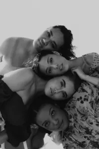 Black and white images of four humans with heads laying on top of one another in opposite directions, all looking at the camera.