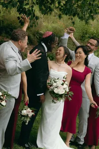 Couple looking at each other on their celebration of love while wedding party gathers around the,