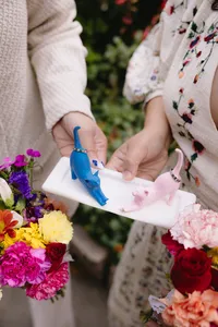 Couple holding blue and pink cat ring holders with colorful flowers